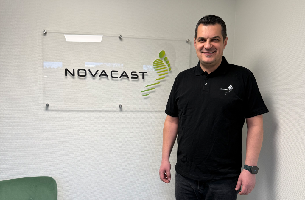 Employee standing next to logowall